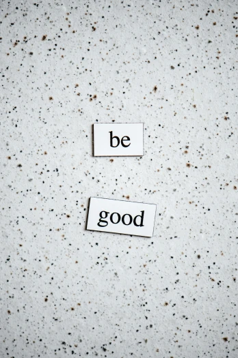 two pieces of paper with the words be good written on them, by Emma Andijewska, trending on unsplash, minimalism, magnetic, robin williams is god, magnesium, back facing