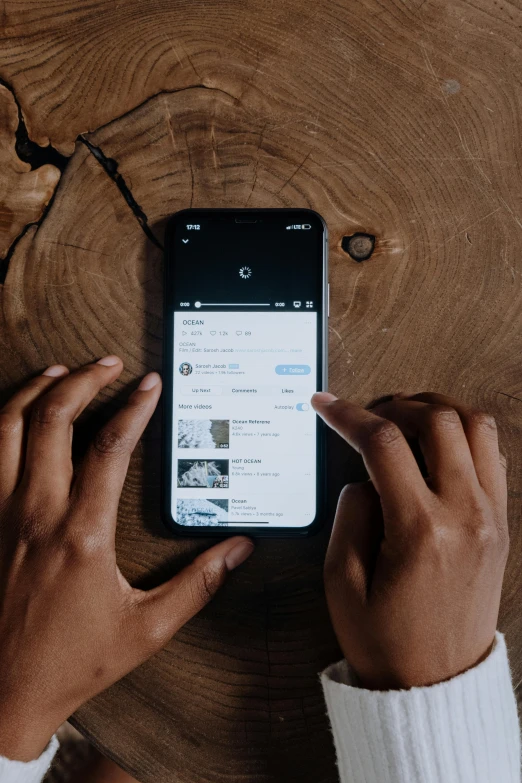 a person using a cell phone on a wooden table, trending on unsplash, happening, tiktok video, black main color, taking from above, ilustration