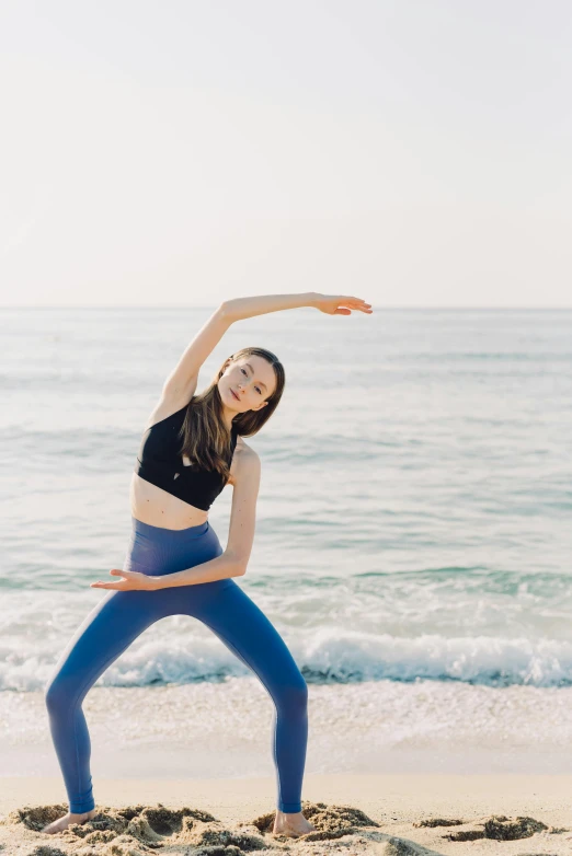 a woman is doing yoga on the beach, unsplash, arabesque, taiwan, profile image, waving, looking partly to the left