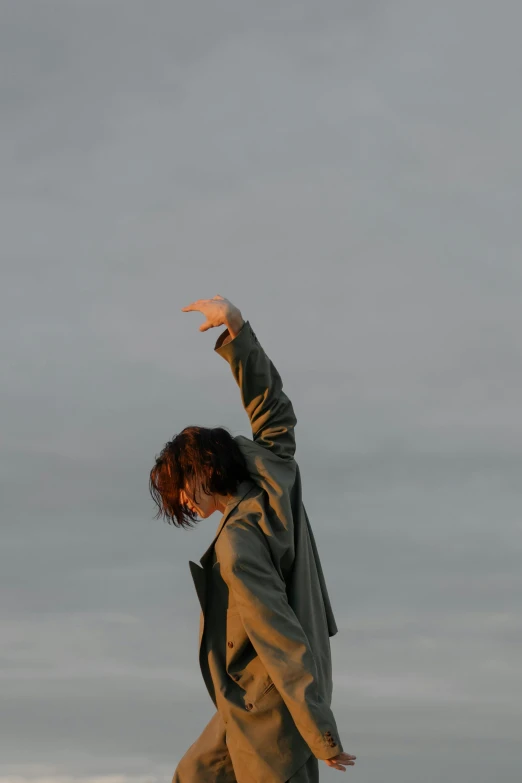 a man riding a snowboard on top of a snow covered slope, by Attila Meszlenyi, pexels, happening, saluting, androgynous person, dancing on the beach, standing in a barren field