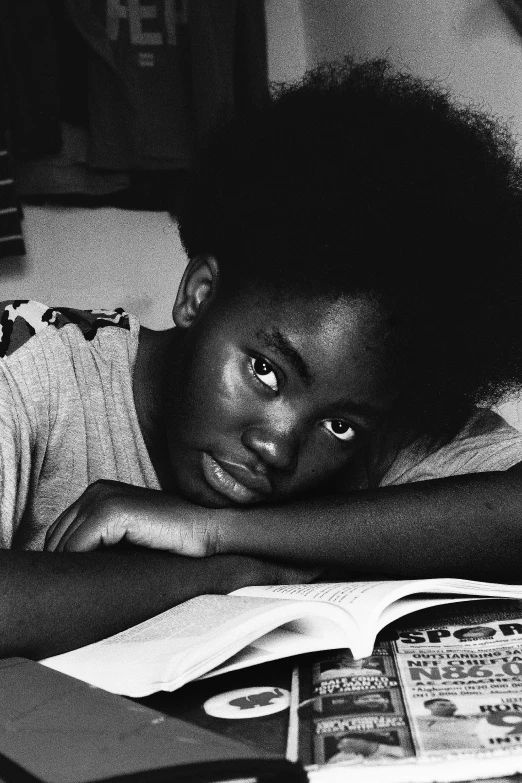 a black and white photo of a boy reading a book, by Glennray Tutor, black arts movement, long afro hair, young woman's face, 1 9 8 5 photograph, lupita nyong'o