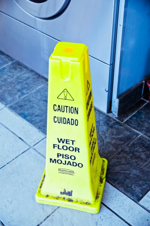 a wet floor sign in front of a washing machine, pexels, hispanic, square, cone shaped, thumbnail