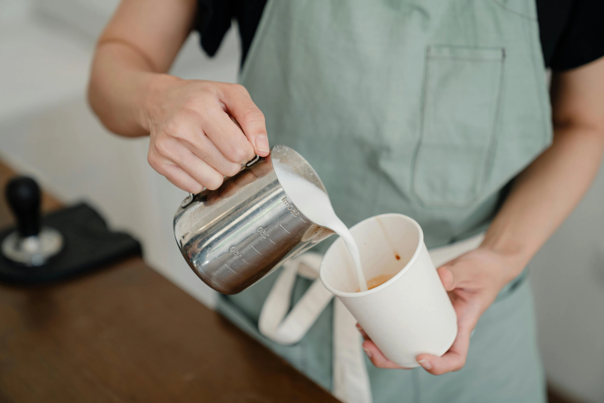 a woman is pouring a cup of coffee, unsplash, made out of shiny white metal, wearing an apron, melbourne, neoprene