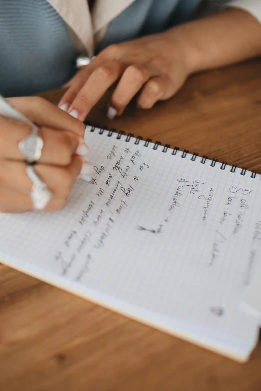 a woman sitting at a table writing in a notebook, by Nicolette Macnamara, easy to use, with notes, close up shot, thumbnail