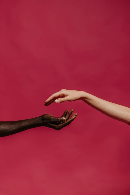 two hands reaching for each other in front of a red background, by Arabella Rankin, aestheticism, varying ethnicities, pink and black, ignant, adut akech