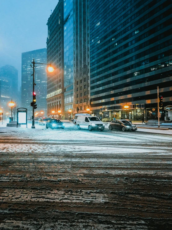 a street filled with lots of snow next to tall buildings, by Greg Rutkowski, pexels contest winner, car shot, chicago, brilliant cold lighting, thumbnail