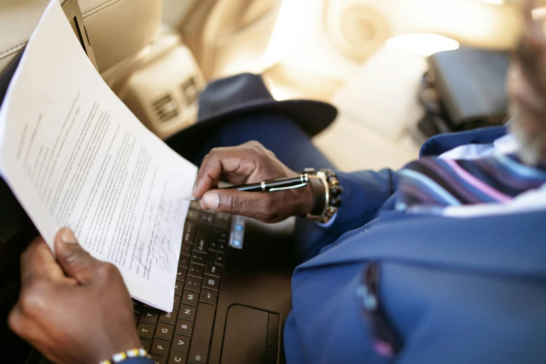 a man sitting in a car using a laptop computer, pexels, private press, signing a bill, aircraft, written in a neat, young thug