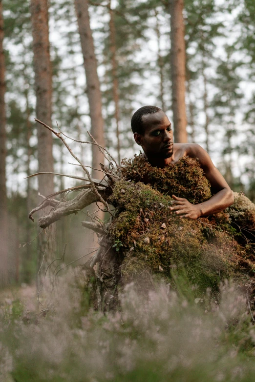 a man that is standing in the grass, inspired by Scarlett Hooft Graafland, unsplash, environmental art, armor made of bark, sitting in the forrest, african woman, finland
