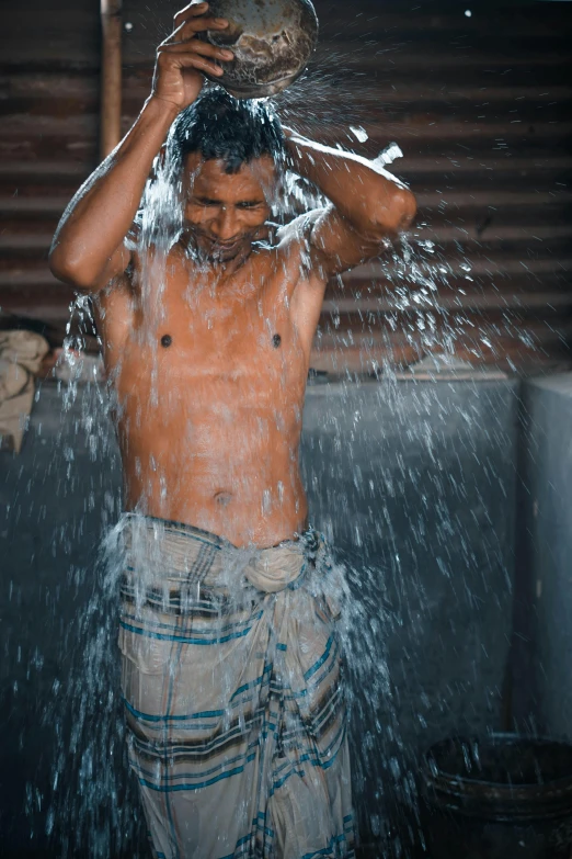 a man with a bucket of water on his head, pexels contest winner, lean man with light tan skin, bathing in light, sri lanka, gif