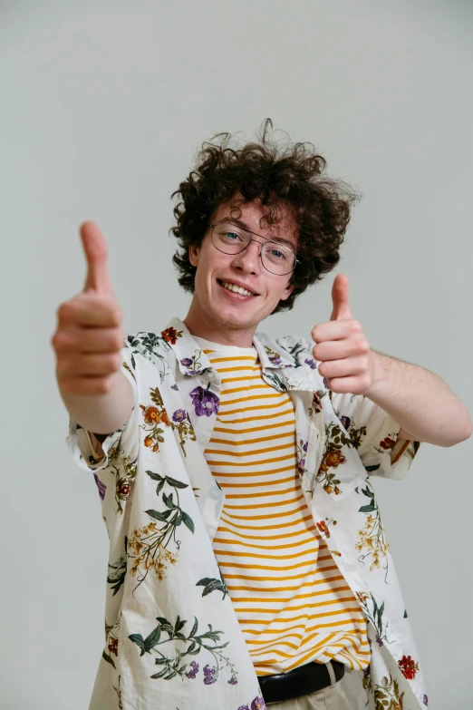 a man with curly hair giving a thumbs up, by Jacob Toorenvliet, trending on pexels, rebecca sugar, patterned clothing, wearing a shirt, profile picture