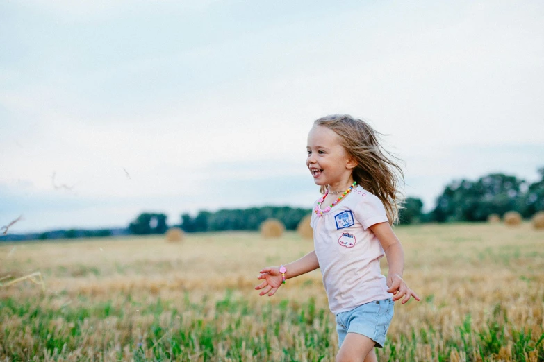 a little girl running in a field with a frisbee, pexels contest winner, greta thunberg smiling, quiet beauty, ad image, wearing farm clothes