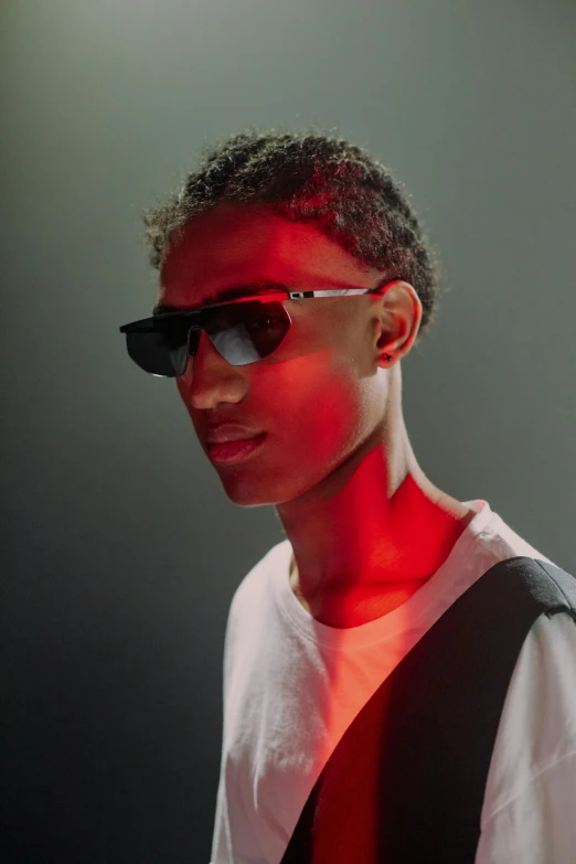 a man wearing sunglasses and a white shirt, red and obsidian neon, black teenage boy, ray lighting from top of frame, non binary model