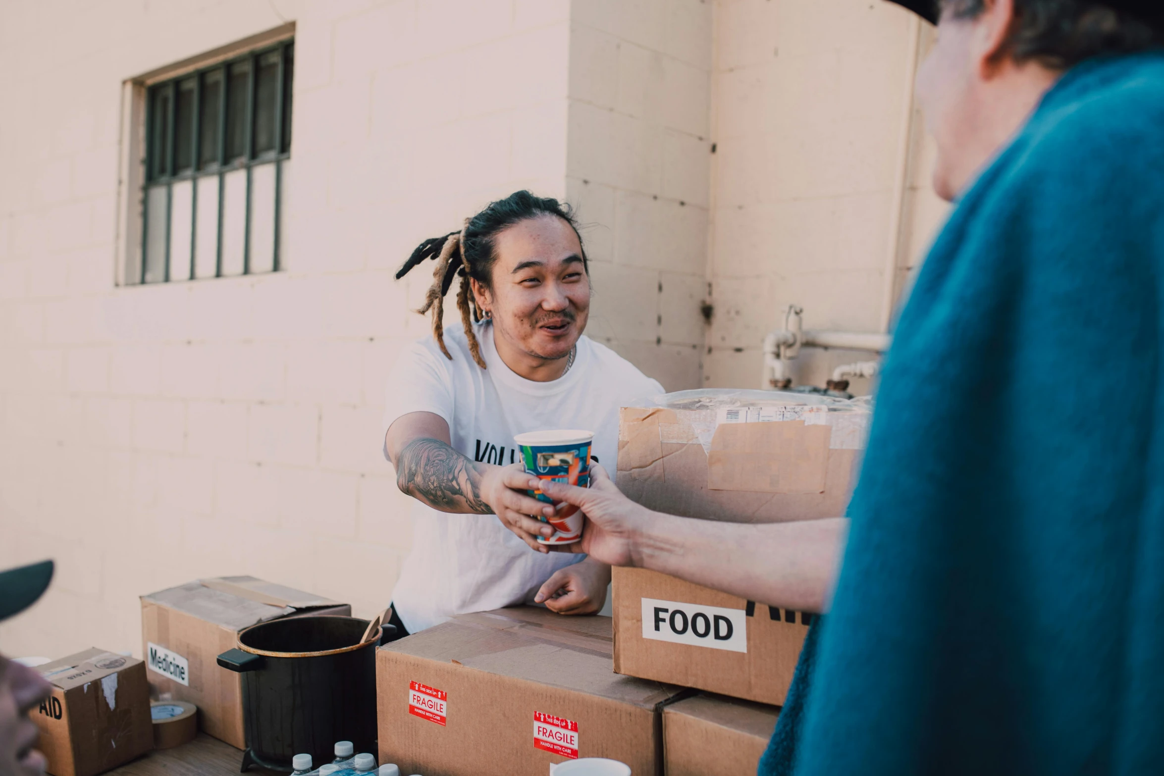 a group of people standing around boxes of food, a photo, frank dillane, avatar image