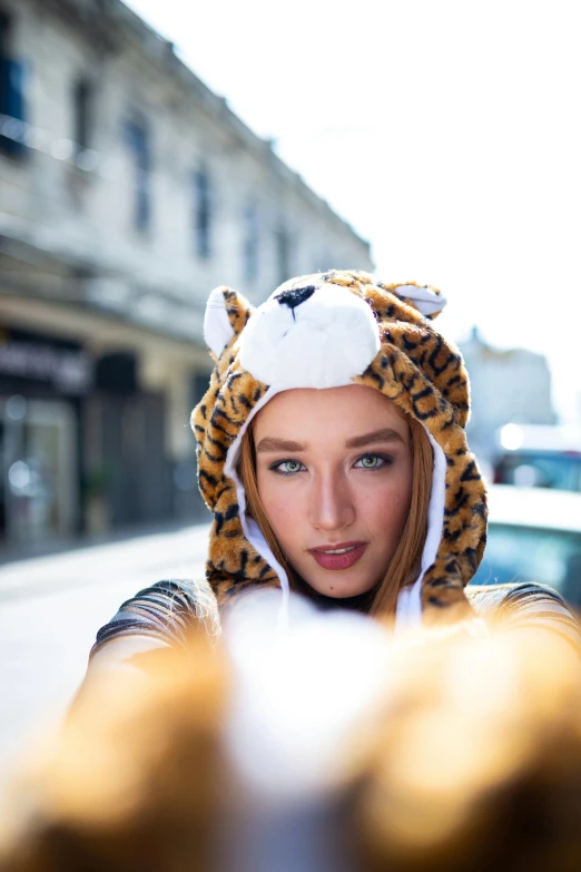 a woman in a tiger costume taking a selfie, by Julia Pishtar, beanie, sydney sweeney, plushy, portrait mode photo