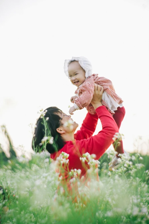 a woman holding a baby in a field of flowers, caring fatherly wide forehead, square, lulu chen, high quality photo