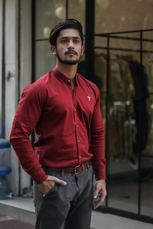 a man in a red shirt standing in front of a building, pexels contest winner, renaissance, bangalore, button up shirt, model shoot, maroon accents