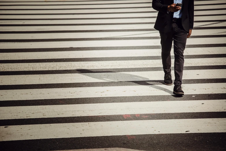 a man in a suit walking across a crosswalk, by Adam Marczyński, trending on unsplash, excessivism, square lines, smartphone photo, fan favorite, brown