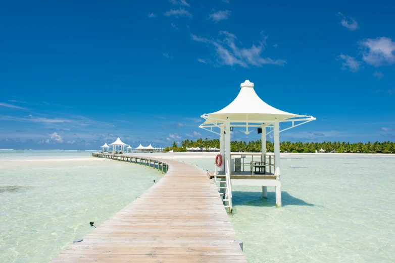 a white gazebo sitting on top of a wooden pier, hurufiyya, crystal clear blue water, with walkways