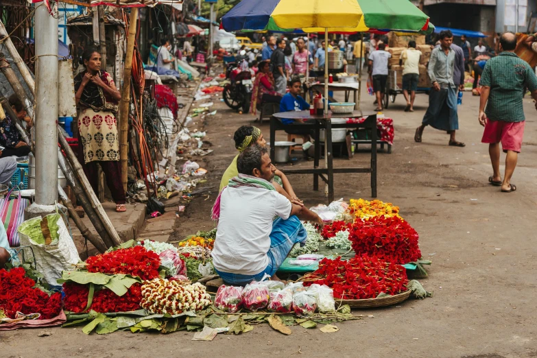 a woman sitting in front of a bunch of flowers, pexels contest winner, hurufiyya, colombo sri lankan city street, fresh food market people, thumbnail, square