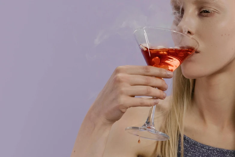 a woman holding a wine glass with a smoke coming out of it, inspired by Nan Goldin, trending on pexels, renaissance, anya taylor - joy, drinking cocktail, red and purple, angled