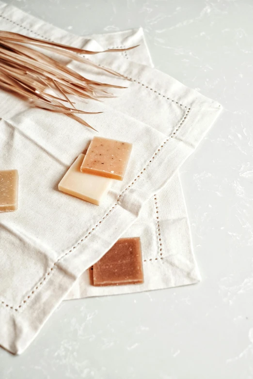 a bunch of soap bars sitting on top of a white cloth, by Jessie Algie, caramel. rugged, thumbnail, square lines, summer setting