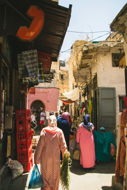 a group of people walking down a street, by Riad Beyrouti, les nabis, crafts and souvenirs, square, vibrant tones, tall