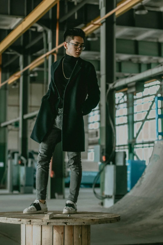 a man standing on top of a wooden box, pexels contest winner, wearing black stylish clothing, stood in a factory, grey turtleneck coat, full body hero