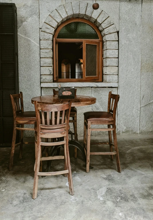 a table and chairs in front of a window, a portrait, unsplash, local bar, stand on stone floor, beautiful aged and rustic finish, promo image