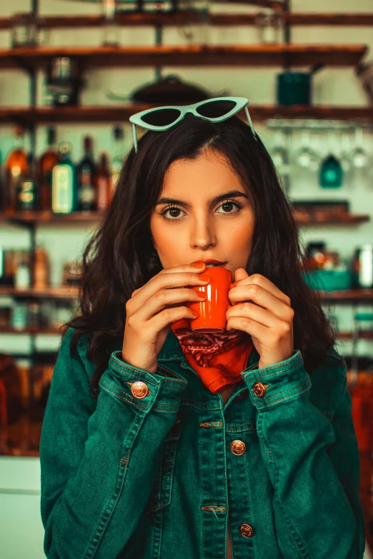 a woman holding a cup of coffee in front of her face, trending on pexels, soda themed girl, in a pub, highly saturated colors, square rimmed glasses