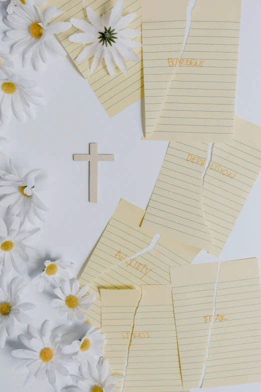 a cross sitting on top of a bunch of flowers, lined paper, scattered props, profile image, trending photo