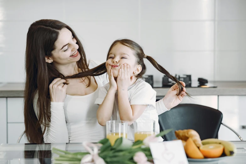 a woman brushing her daughter's hair in the kitchen, pexels contest winner, avatar image, playful smile, 1 4 9 3, woman with braided brown hair