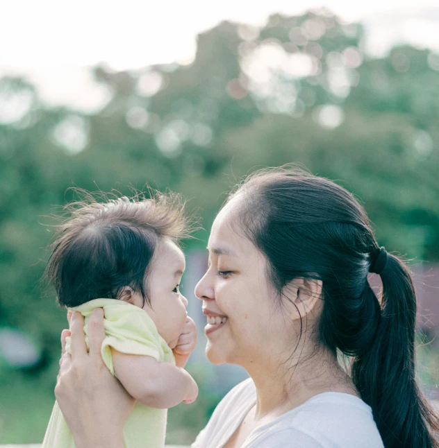 a woman holding a baby in her arms, inspired by Ruth Jên, pexels contest winner, avatar image, asian female, profile pic, high resolution photo