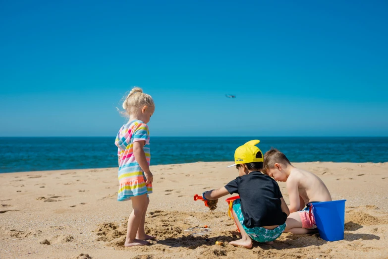 two children playing in the sand at the beach, by Liza Donnelly, pexels contest winner, airplanes bombing the beach, profile image, multicoloured, three - quarter view