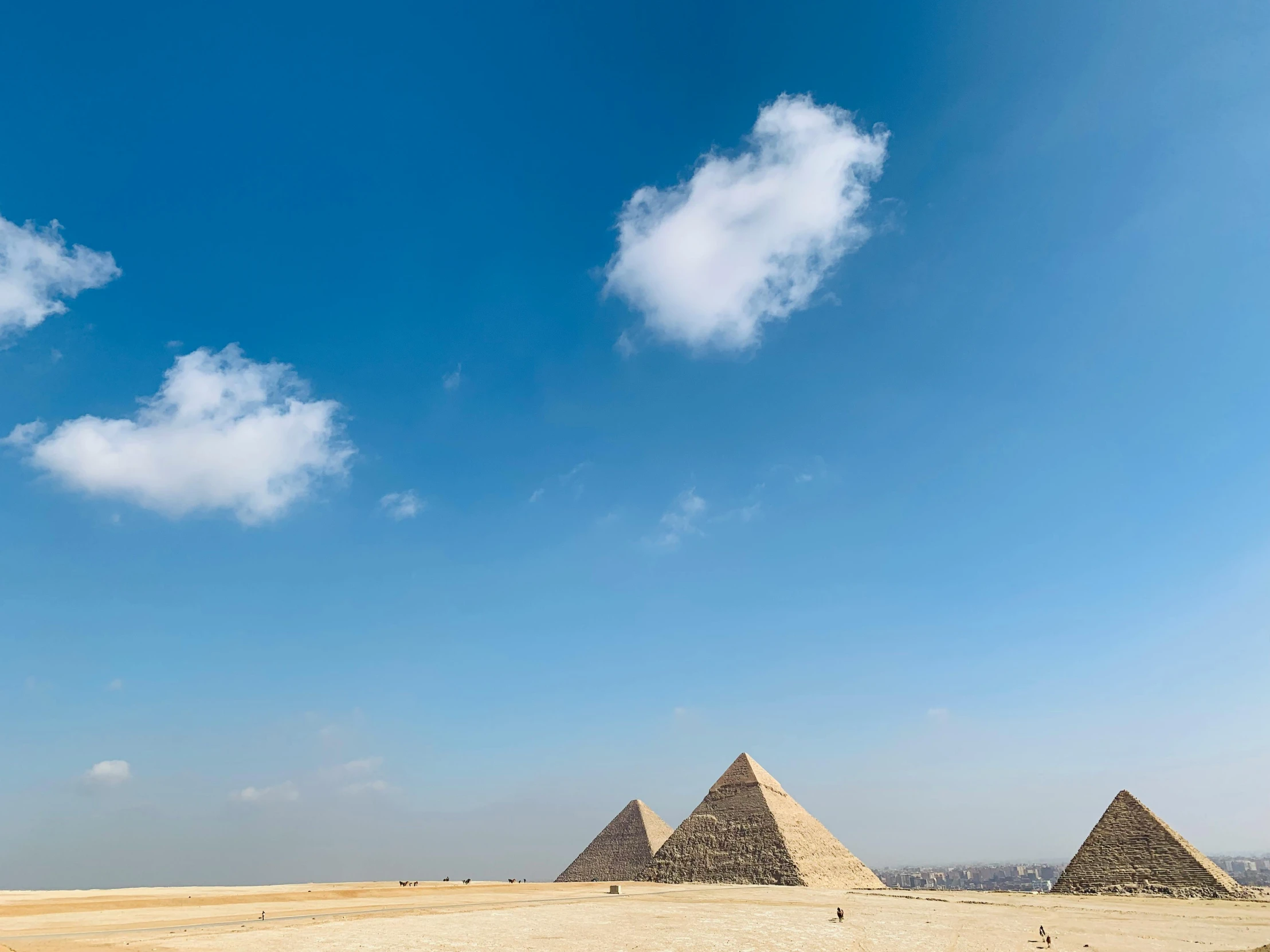 three pyramids in the desert under a blue sky, egyptian art, pexels contest winner, palace floating in the sky, foster and partners, clouds around, 2000s photo