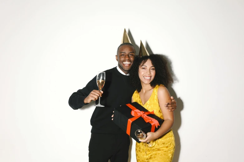 a man and a woman standing next to each other, pexels contest winner, wearing a party hat, holding a gold bag, diverse, gif