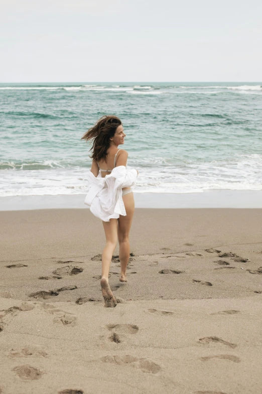 a woman in a white dress running on a beach, pexels contest winner, renaissance, wavy hair spread out, ana de armas, puerto rico, white loincloth