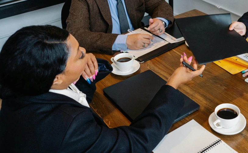 a group of people sitting around a wooden table, woman in business suit, abcdefghijklmnopqrstuvwxyz, thumbnail, high-resolution