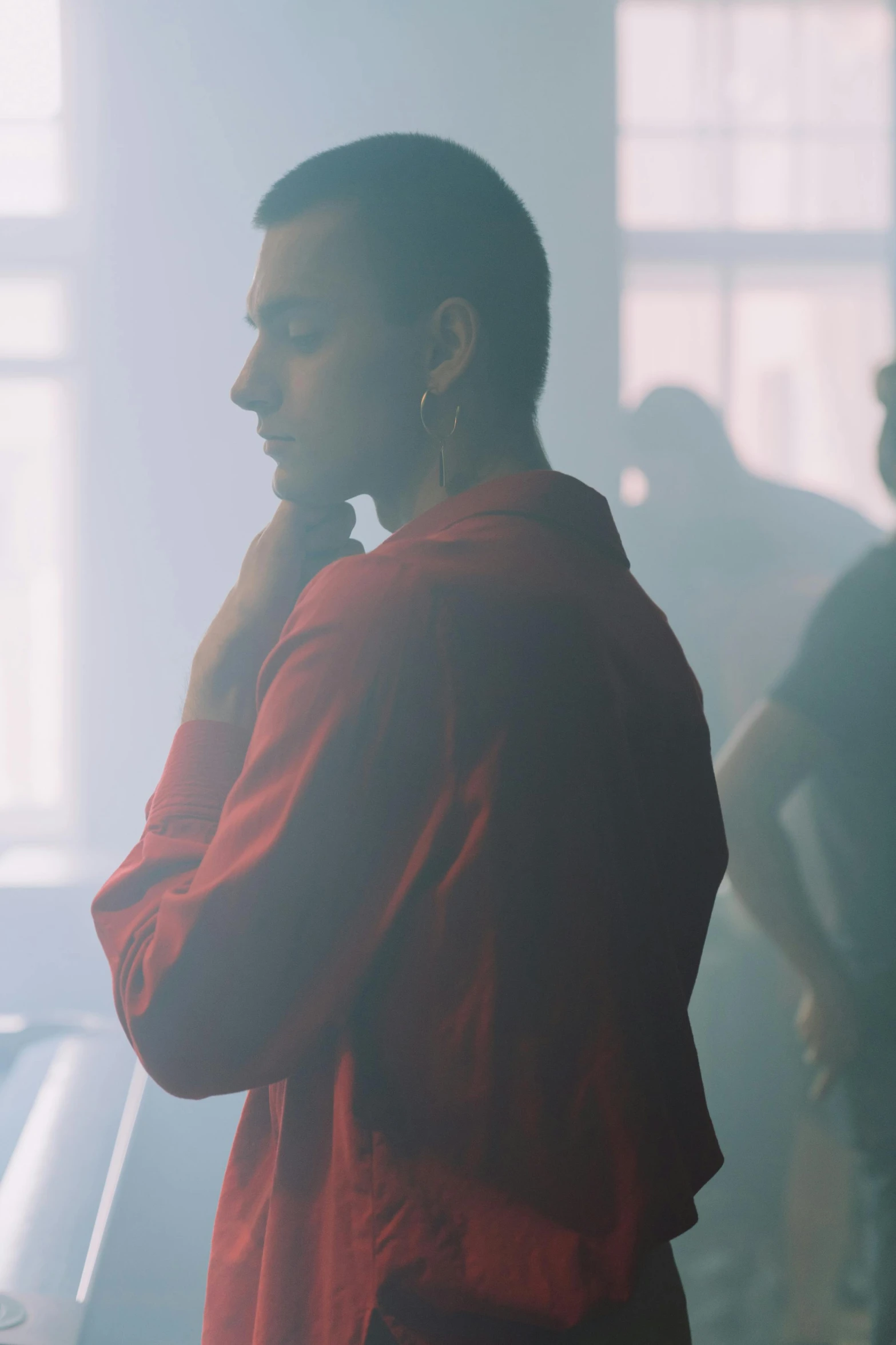a man in a red shirt talking on a cell phone, an album cover, inspired by Elsa Bleda, trending on unsplash, smoke filled room, slicked back hair, at a fashion shoot, still from a music video