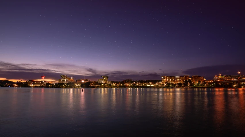 a large body of water with a city in the background, by Washington Allston, pexels contest winner, hurufiyya, evening starlight, manly, slide show, high resolution photo