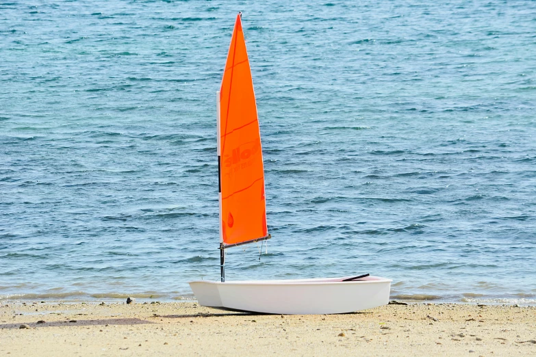 a small sailboat sitting on top of a sandy beach, by Liza Donnelly, unsplash, replica model, white and orange, full lenght view. white plastic, skiff