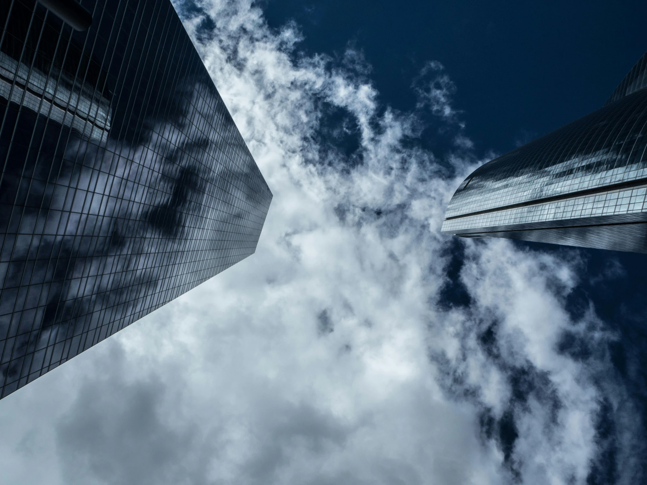 a couple of tall buildings that are next to each other, a picture, by Adam Marczyński, pexels contest winner, modernism, volumetric clouds, close-up photograph, thumbnail, turbulent