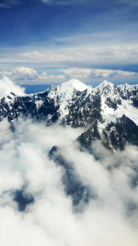 a view of snow covered mountains from an airplane, an album cover, trending on unsplash, sumatraism, multiple stories, alaska, climbing, conde nast traveler photo