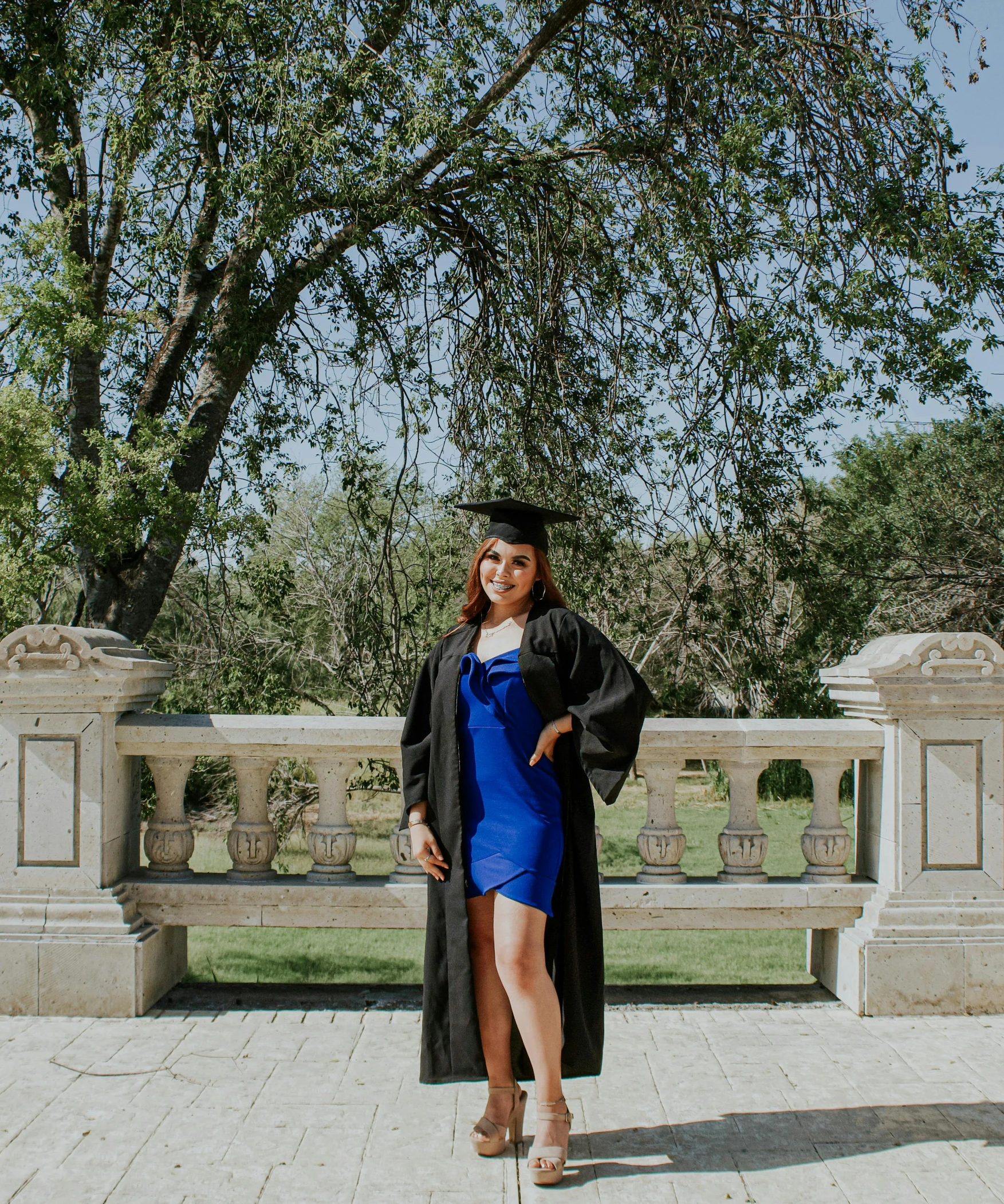 a woman in a graduation gown posing for a picture, by Robbie Trevino, unsplash, wearing a toga and sandals, estefania villegas burgos, stately, low quality photo