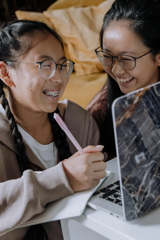 two girls sitting in front of a laptop computer, by Reuben Tam, trending on pexels, wearing small round glasses, teaching, banner, full frame image