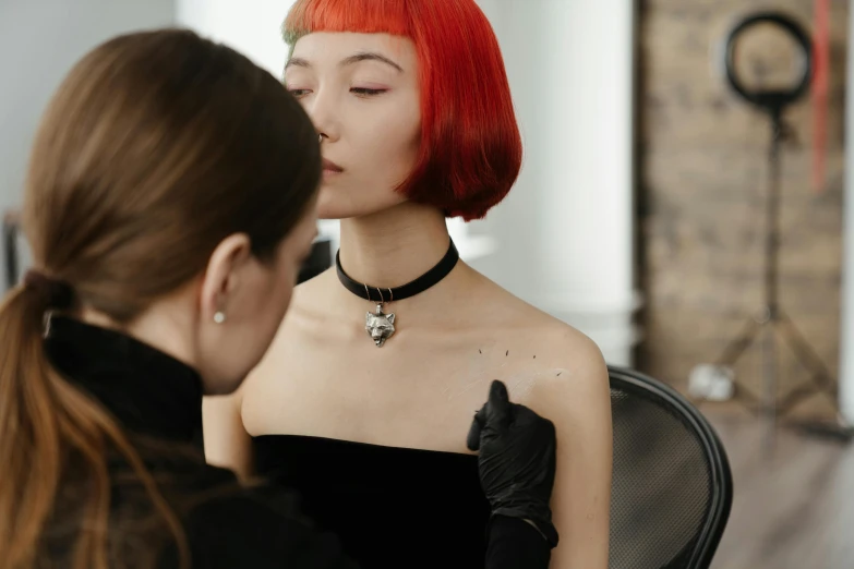 a woman with red hair getting her make - up done, a hyperrealistic painting, trending on pexels, wearing detailed leather collar, french bob, woman holding another woman, an asian woman