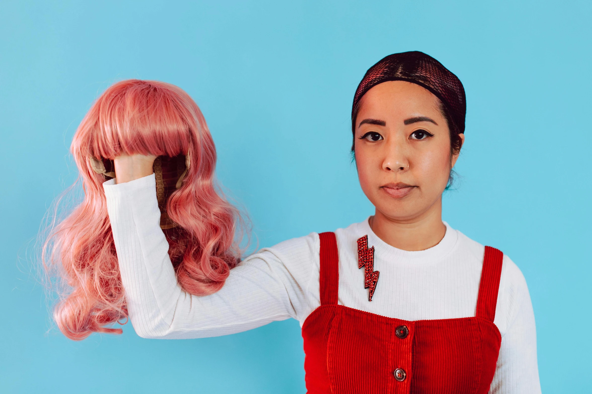 a woman in a red dress holding a pink wig, inspired by Kanō Tan'yū, trending on pexels, artist wearing overalls, asian descent, stop motion character, wearing a headband