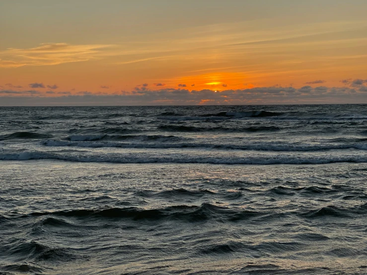 a sunset over the ocean with waves in the foreground, by Carey Morris, pexels contest winner, slight overcast weather, sunset panorama, modeled, mid view