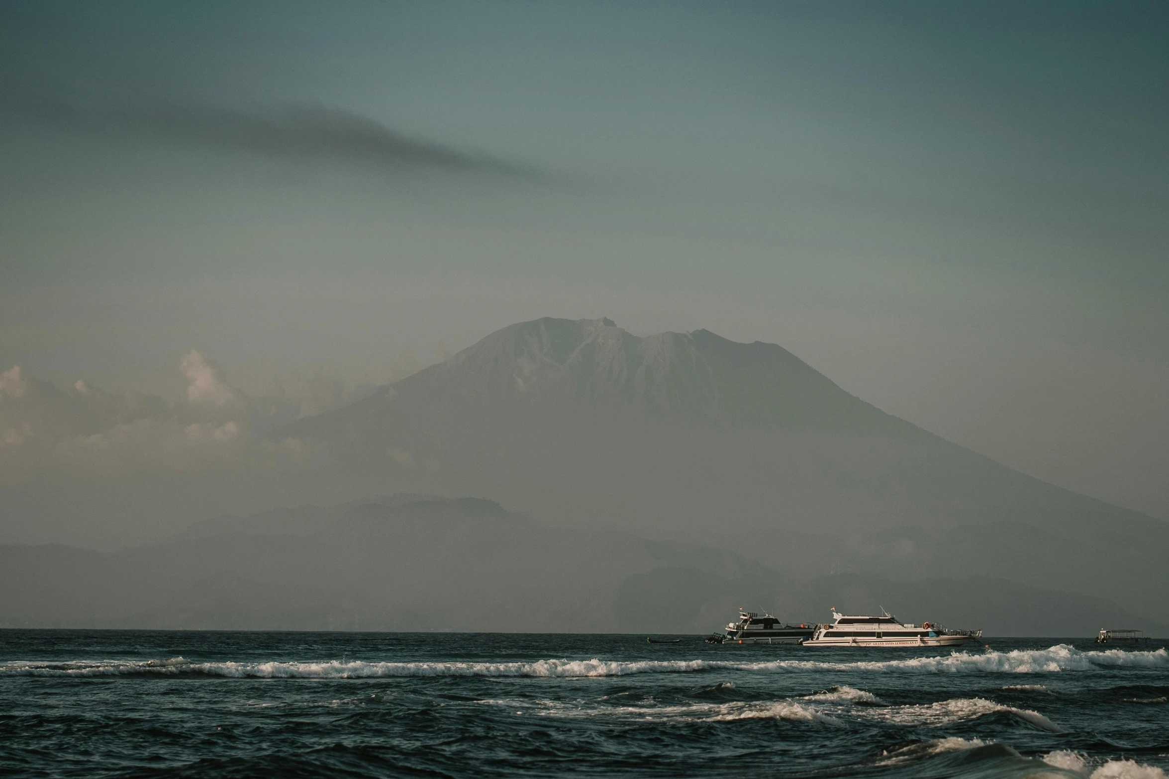 a boat in the ocean with a mountain in the background, by Daniel Lieske, pexels contest winner, sumatraism, kamakura scenery, slide show, stacked image, extremely high resolution