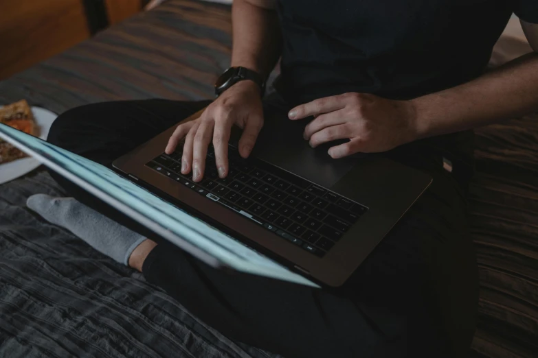 a man sitting on a bed using a laptop computer, pexels, wearing a dark shirt and jeans, keyboard, casey cooke, detailed and soft