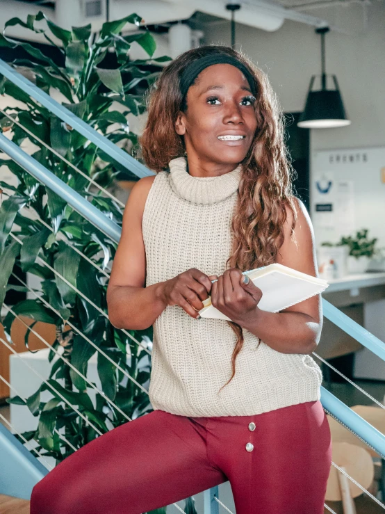 a woman sitting on top of a set of stairs, by Louisa Puller, trending on unsplash, happening, portrait of ororo munroe, holding notebook, wearing a vest top, wearing turtleneck